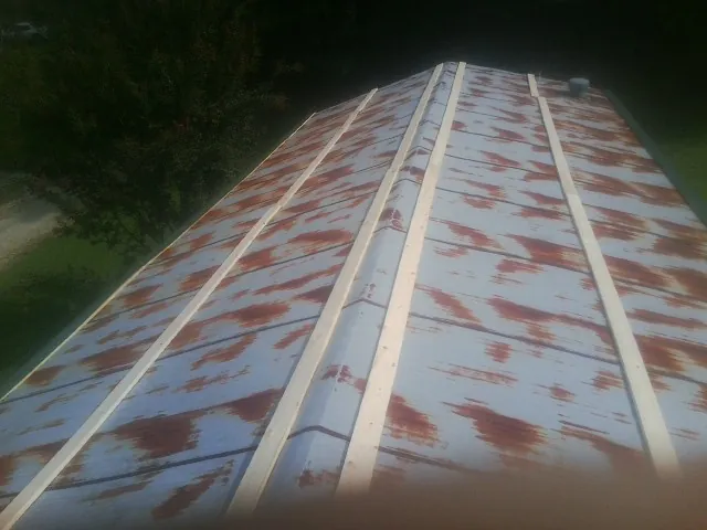 Rusted metal roof panels with new wood purlins before replacement — Storm Damage Roof Repair in Gerton by Roofing Brothers