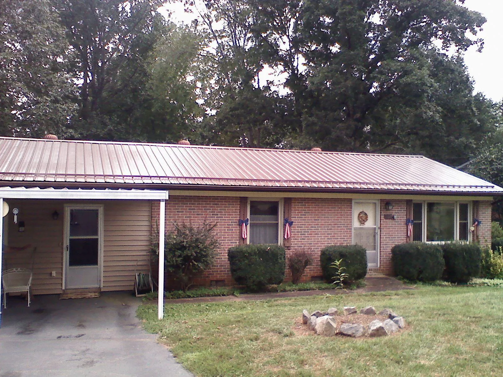 Bronze metal roof and carport on a brick ranch home — Roof Repair work by our crew in Gerton